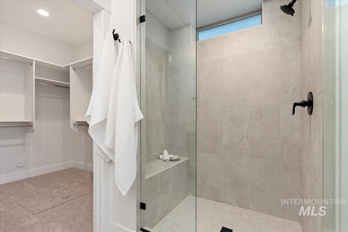 Full bath with a tile shower and a spacious closet