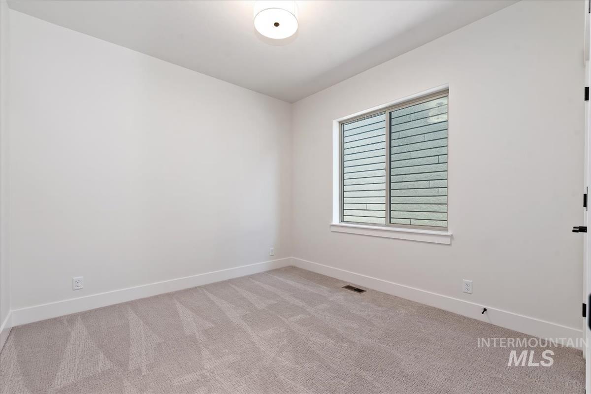 Spare room with light colored carpet and baseboards