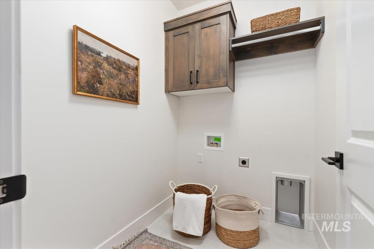 Washroom featuring hookup for a washing machine, cabinet space, and hookup for an electric dryer