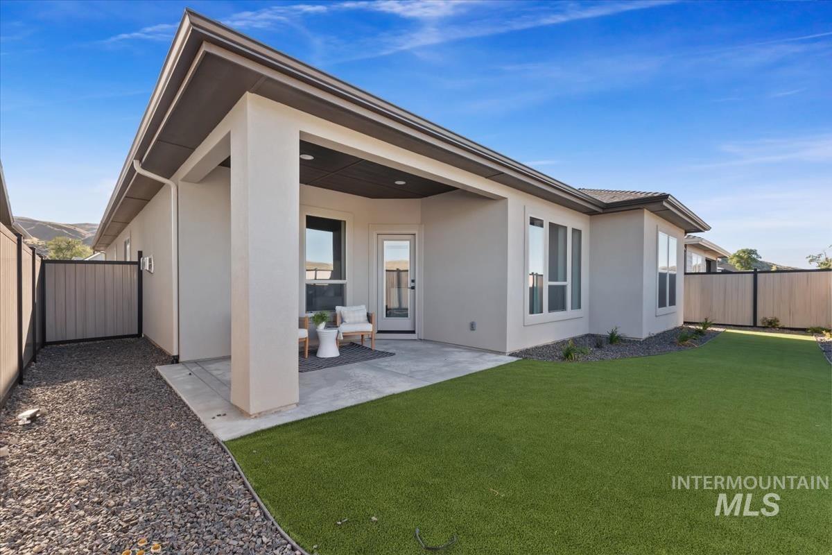 Back of house featuring stucco siding, a fenced backyard, and a patio