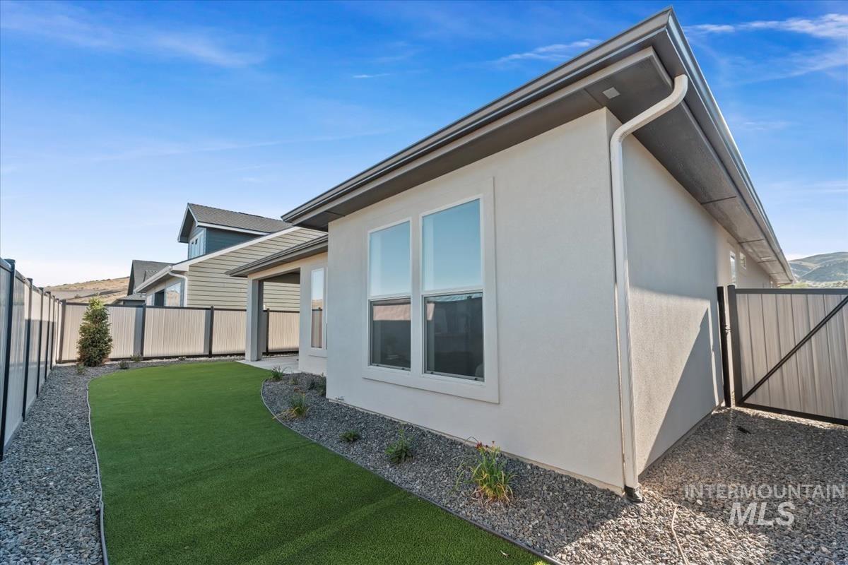 View of side of home with stucco siding and a fenced backyard