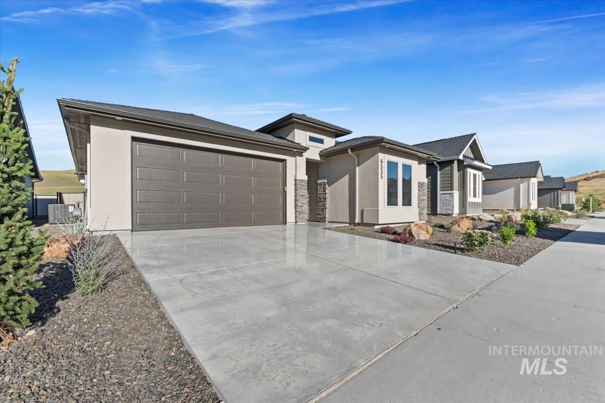 Prairie-style house with a garage, concrete driveway, and stucco siding