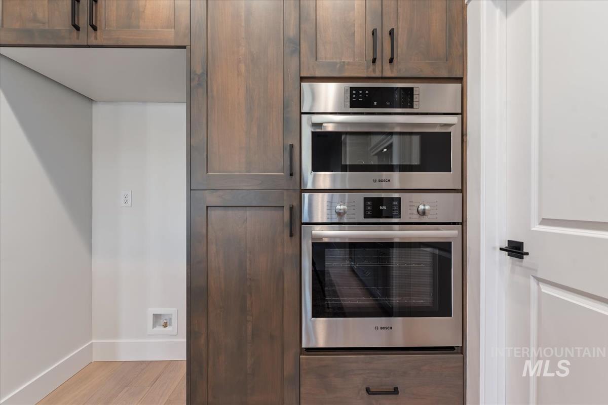 Kitchen featuring stainless steel double oven and light wood-style floors