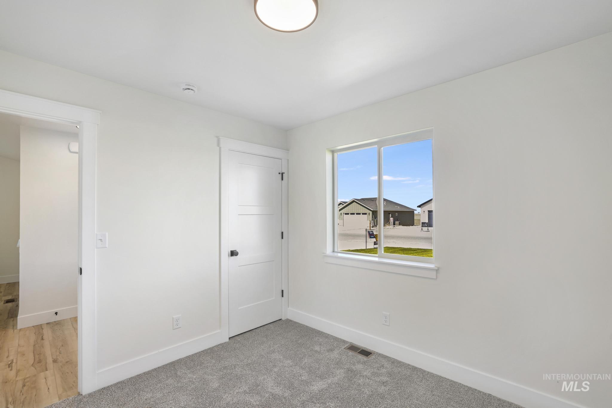 Unfurnished bedroom with light carpet and a closet