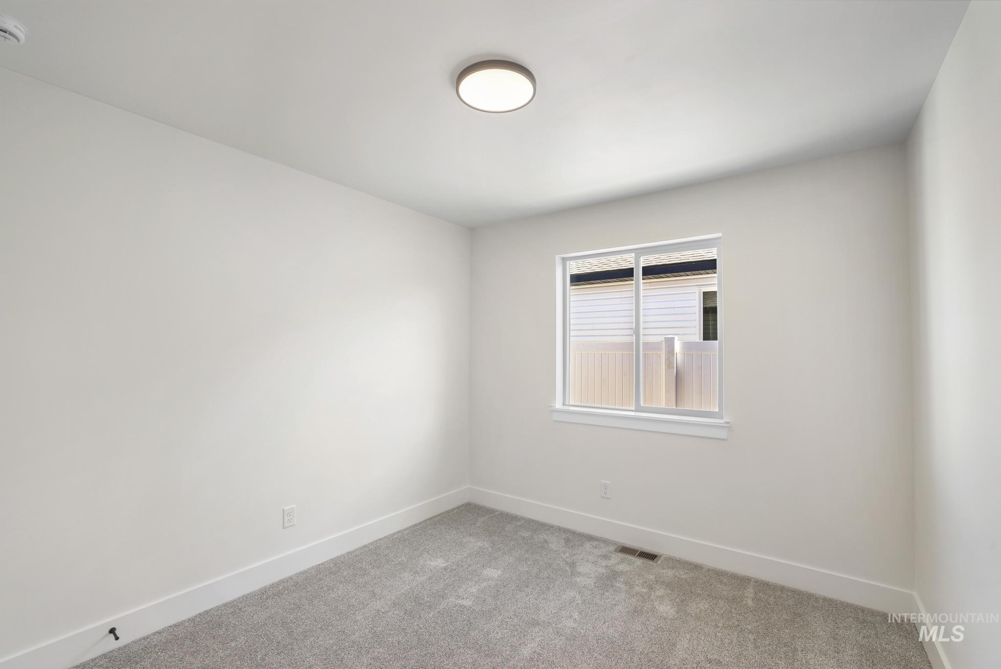 Carpeted empty room with baseboards
