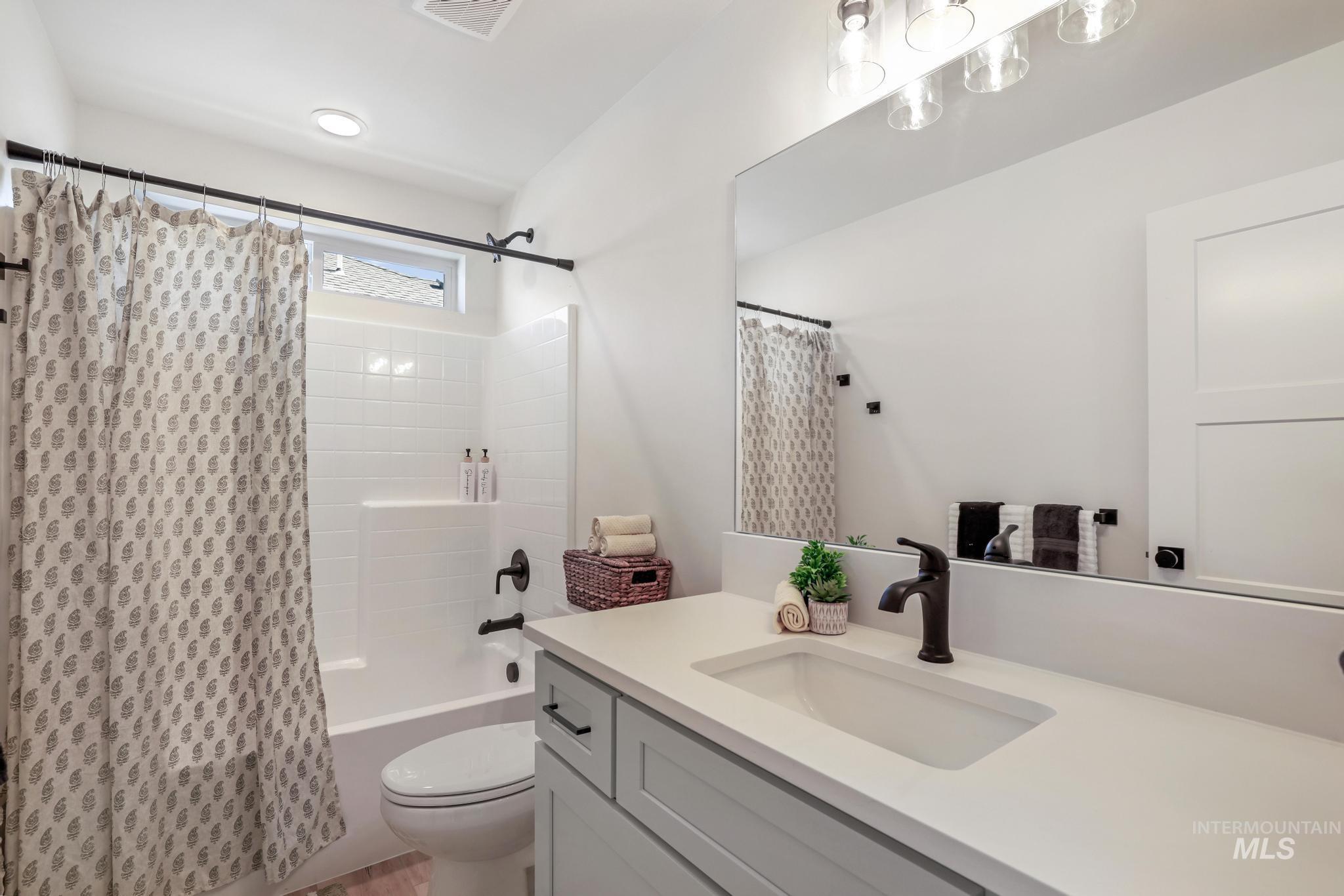 Bathroom with shower / tub combo with curtain and vanity