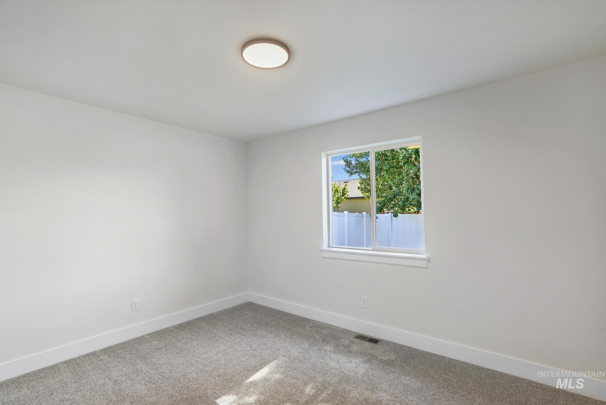 Spare room featuring baseboards and carpet floors