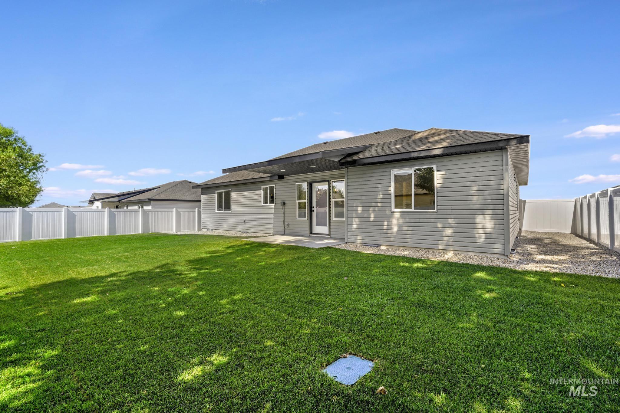Rear view of house featuring a fenced backyard, a patio area, and a shingled roof