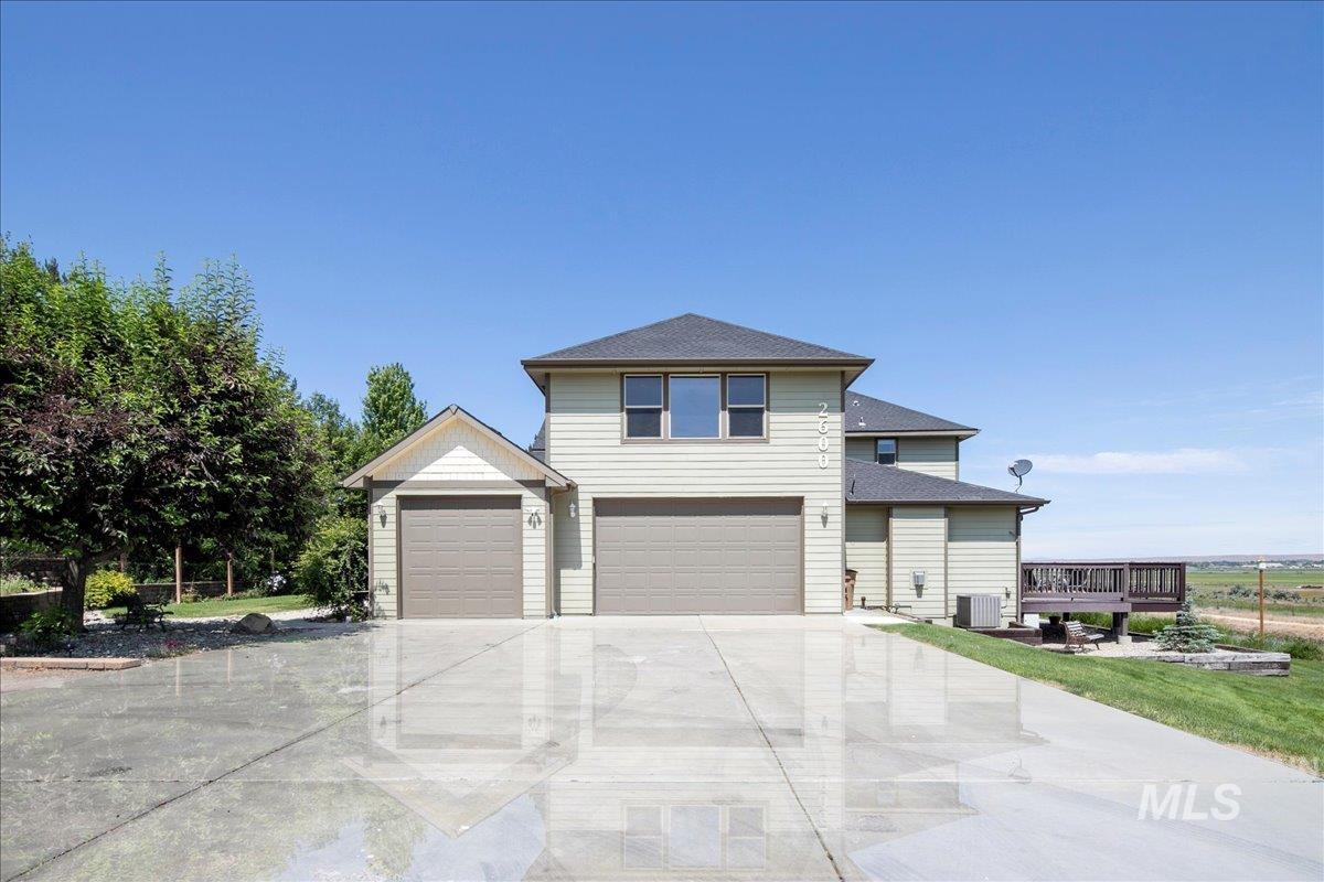 View of front of home with concrete driveway, a garage, and a shingled roof