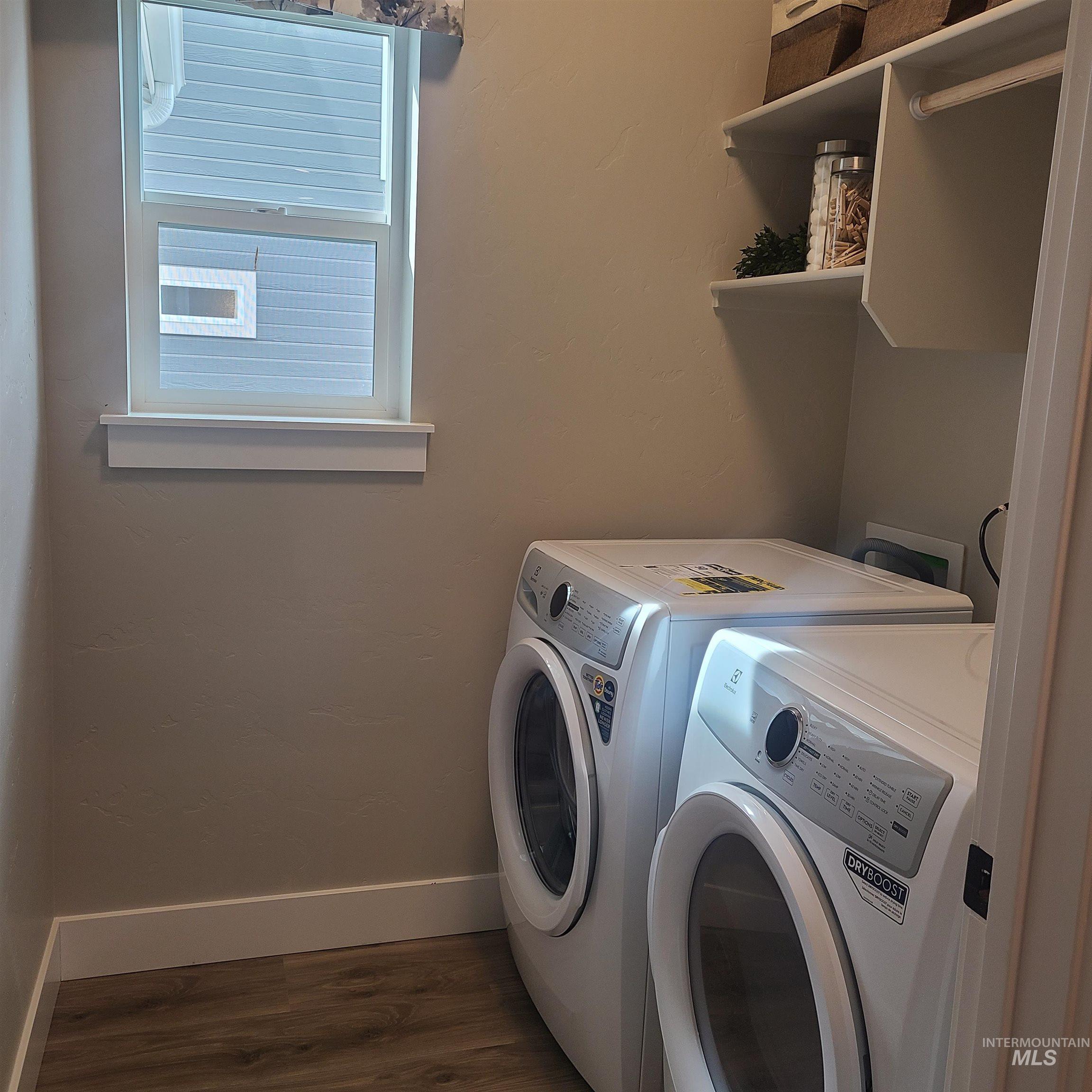 Laundry area with dark wood-type flooring and washing machine and clothes dryer