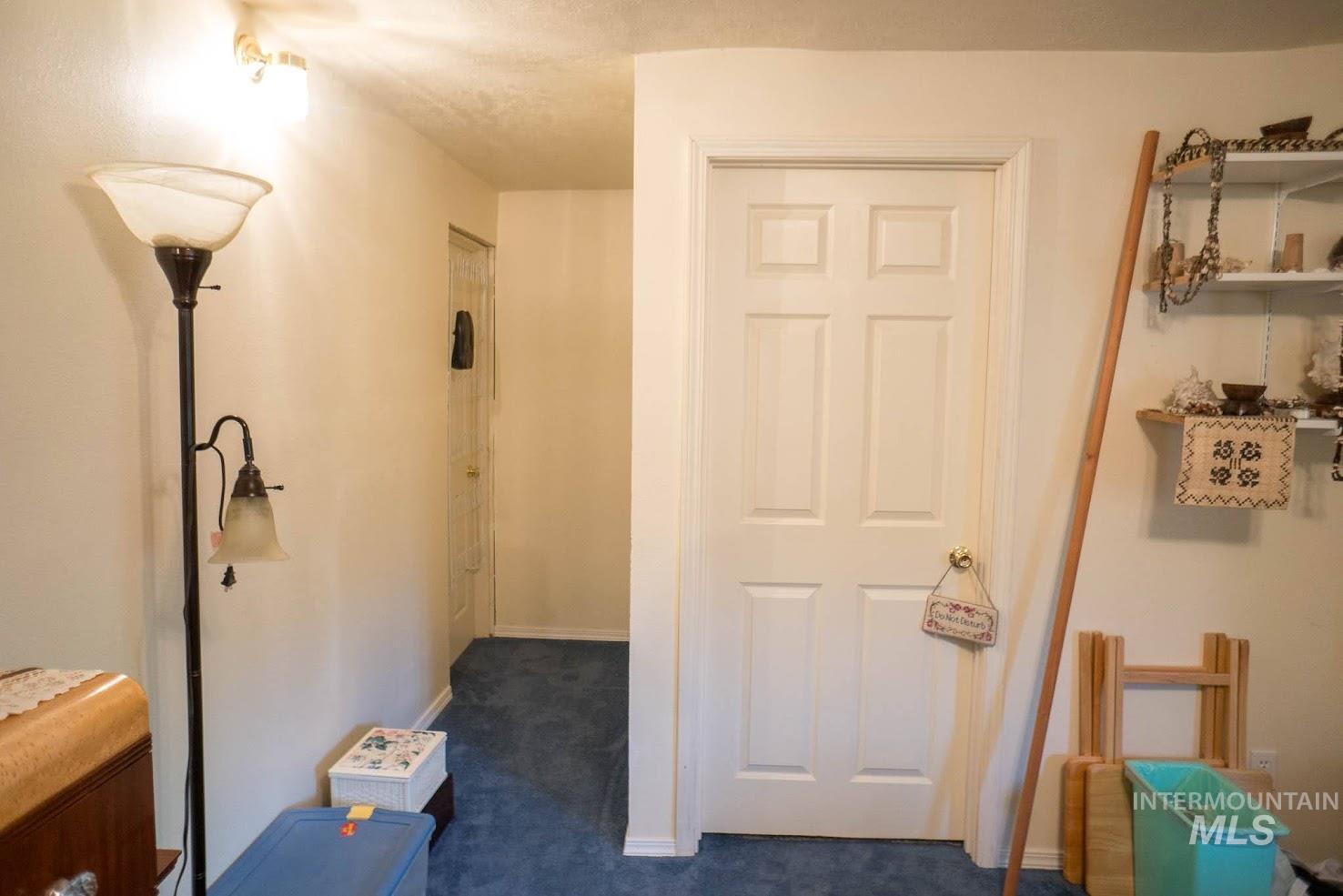 Hall featuring dark carpet and baseboards