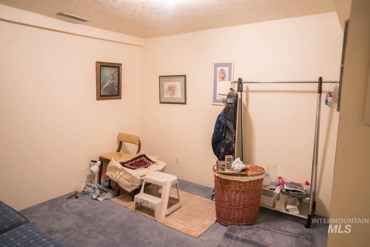 Living area with carpet flooring and a textured ceiling