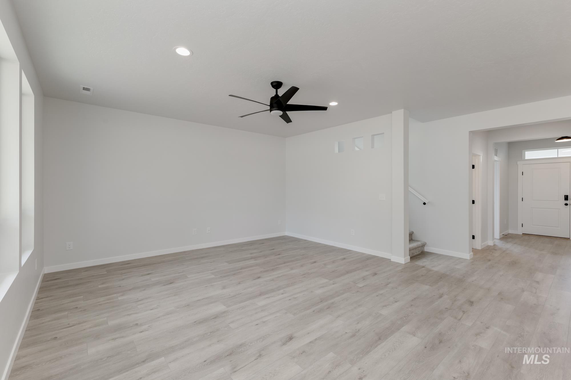 Unfurnished room with a ceiling fan, stairs, recessed lighting, and light wood-style floors