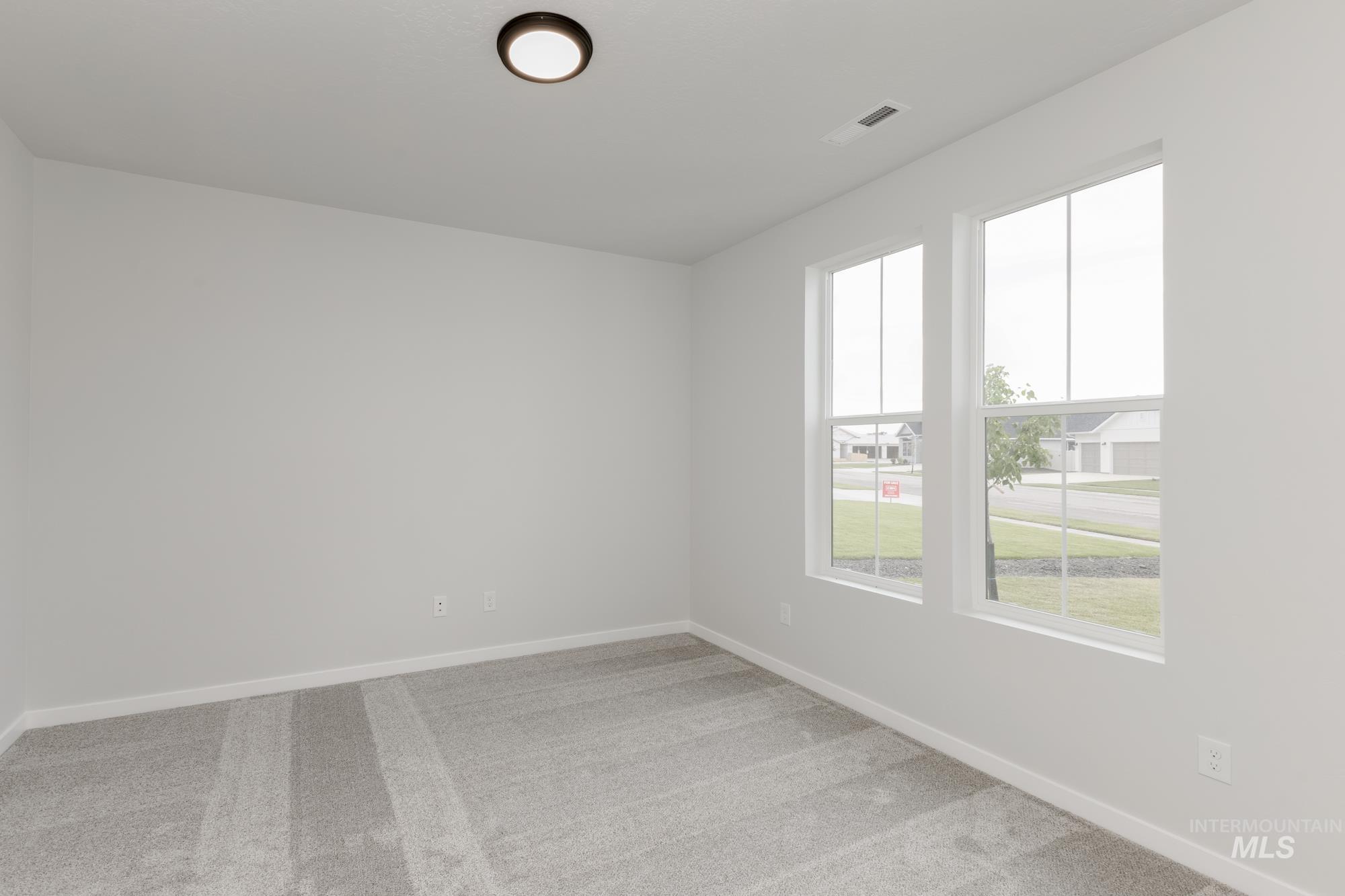 Unfurnished room with healthy amount of natural light and light colored carpet