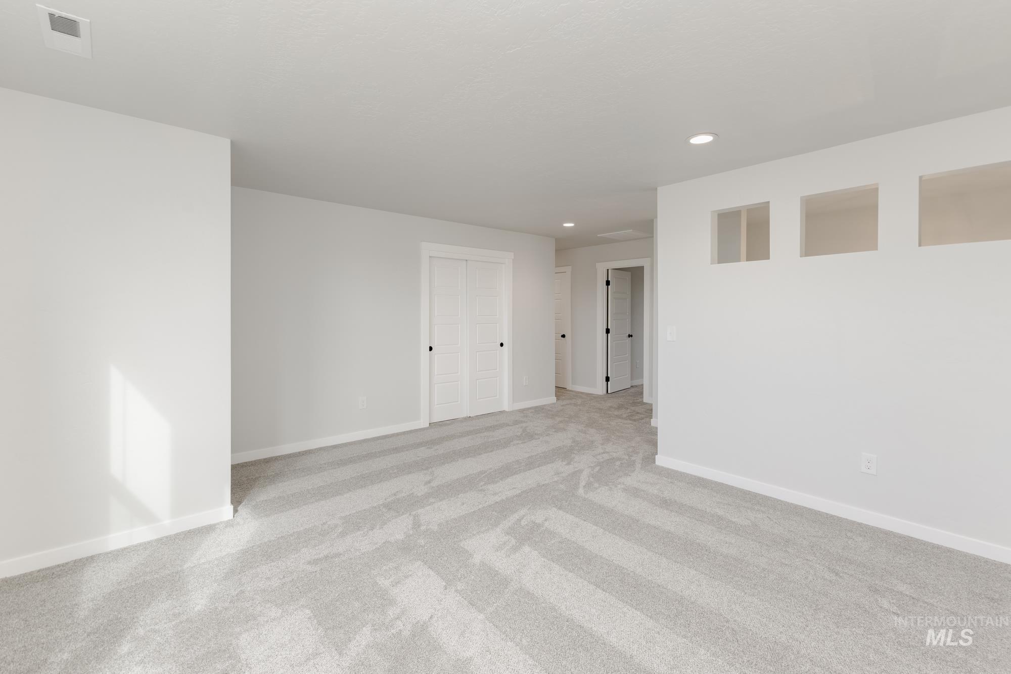 Empty room featuring recessed lighting and light colored carpet