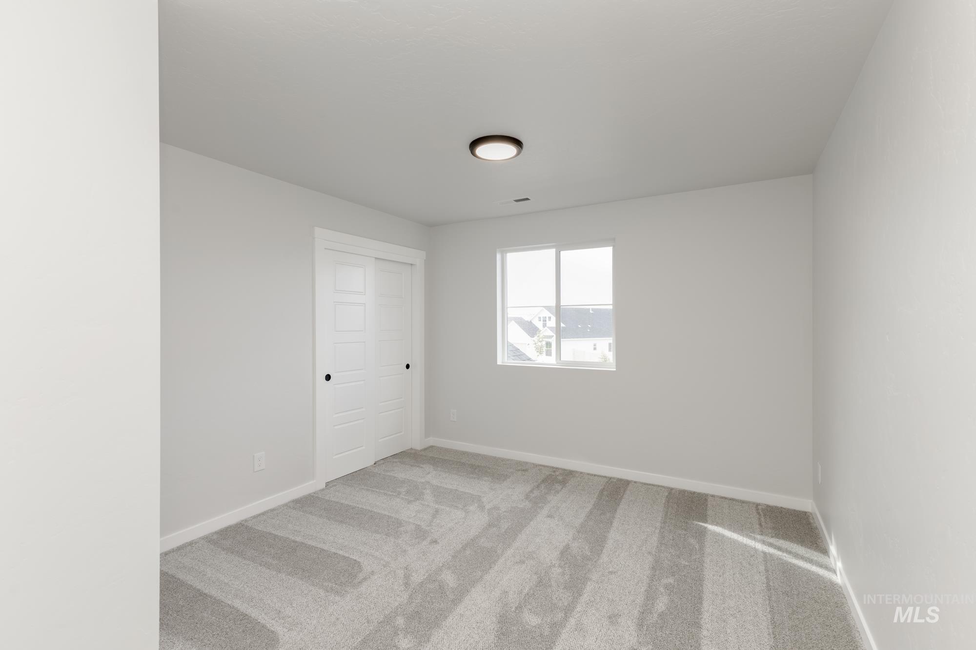Empty room featuring baseboards and light carpet