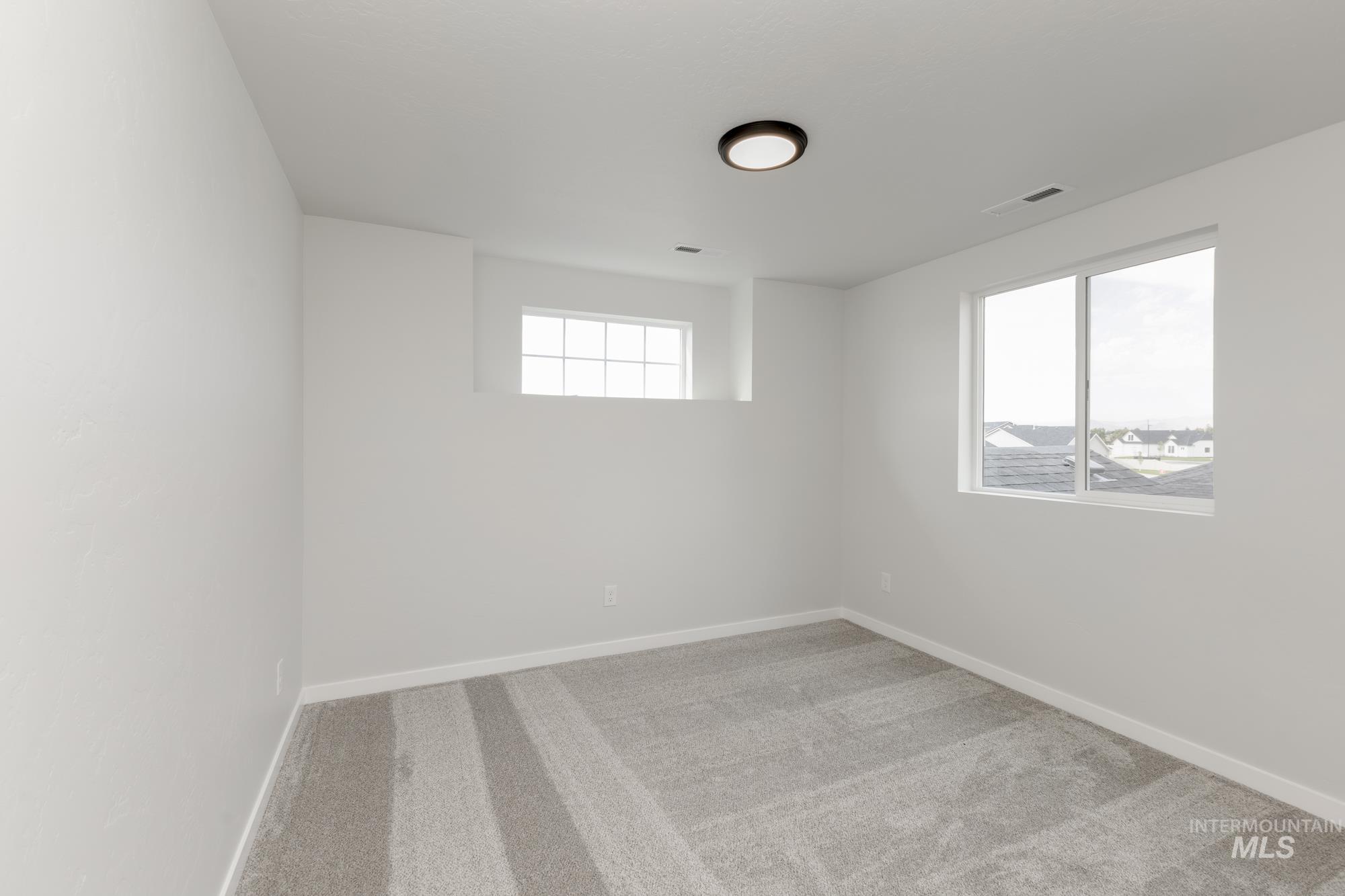 Empty room featuring carpet flooring and baseboards