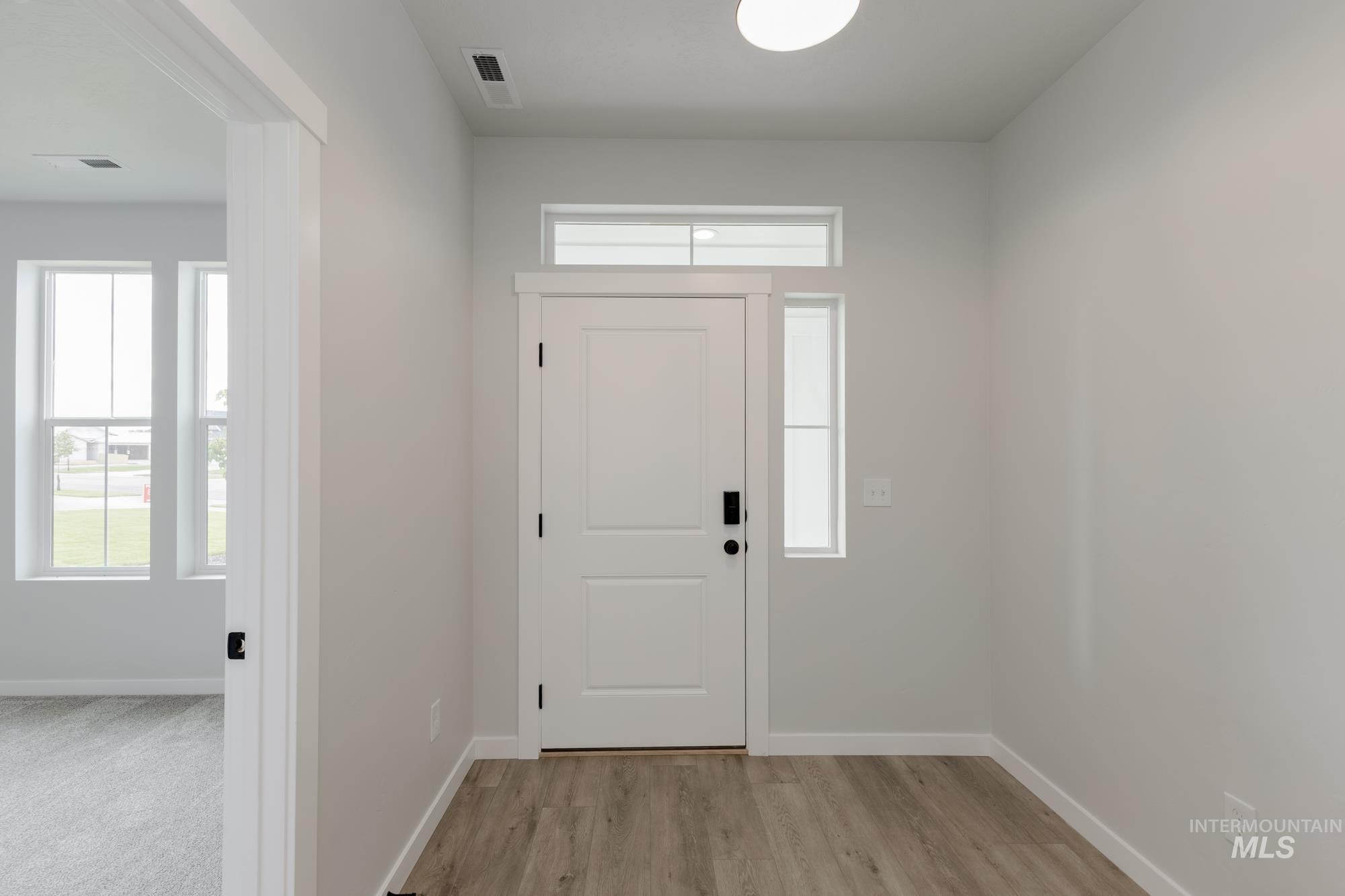 Entrance foyer with plenty of natural light and light wood-style flooring