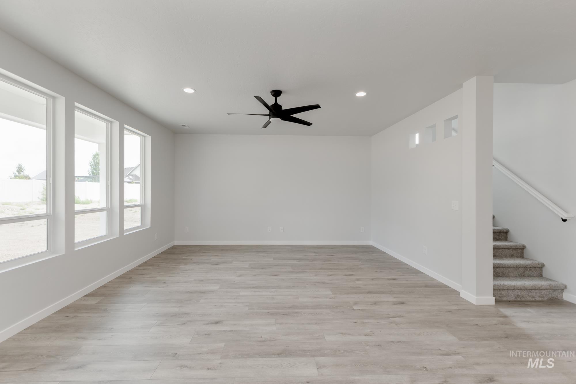 Spare room with recessed lighting, stairs, ceiling fan, and light wood-style flooring