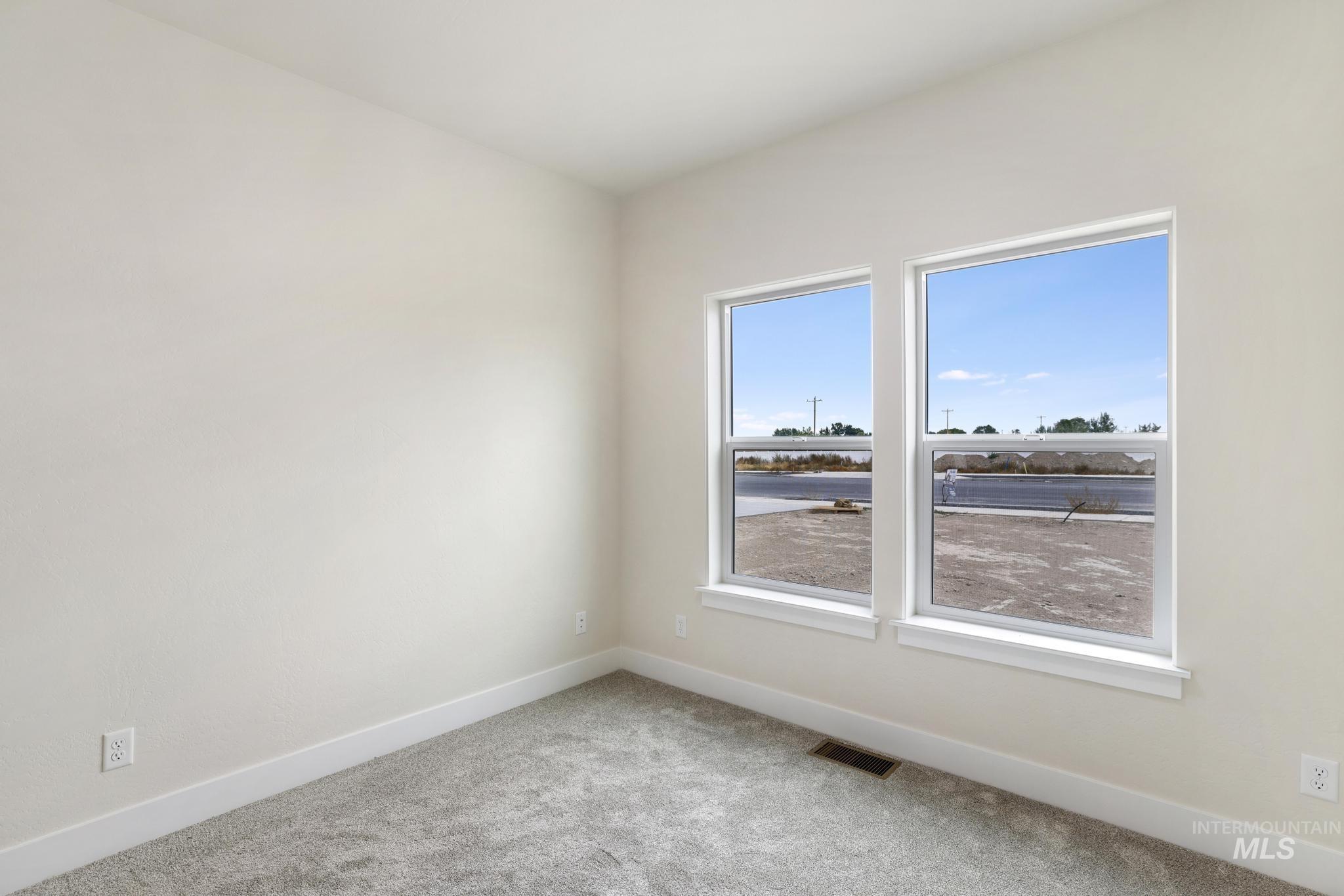 Empty room featuring baseboards and carpet