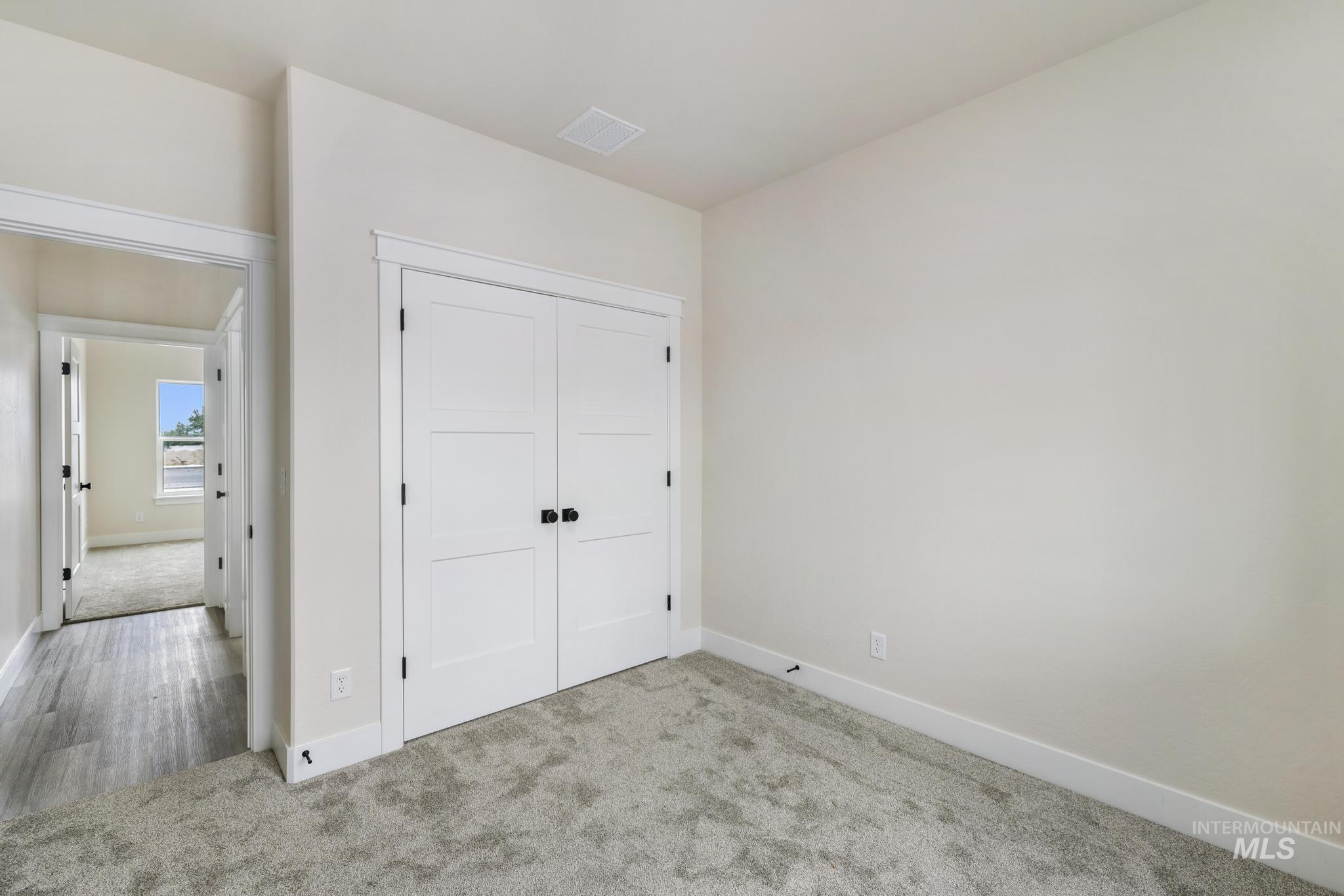 Unfurnished bedroom featuring carpet flooring and a closet