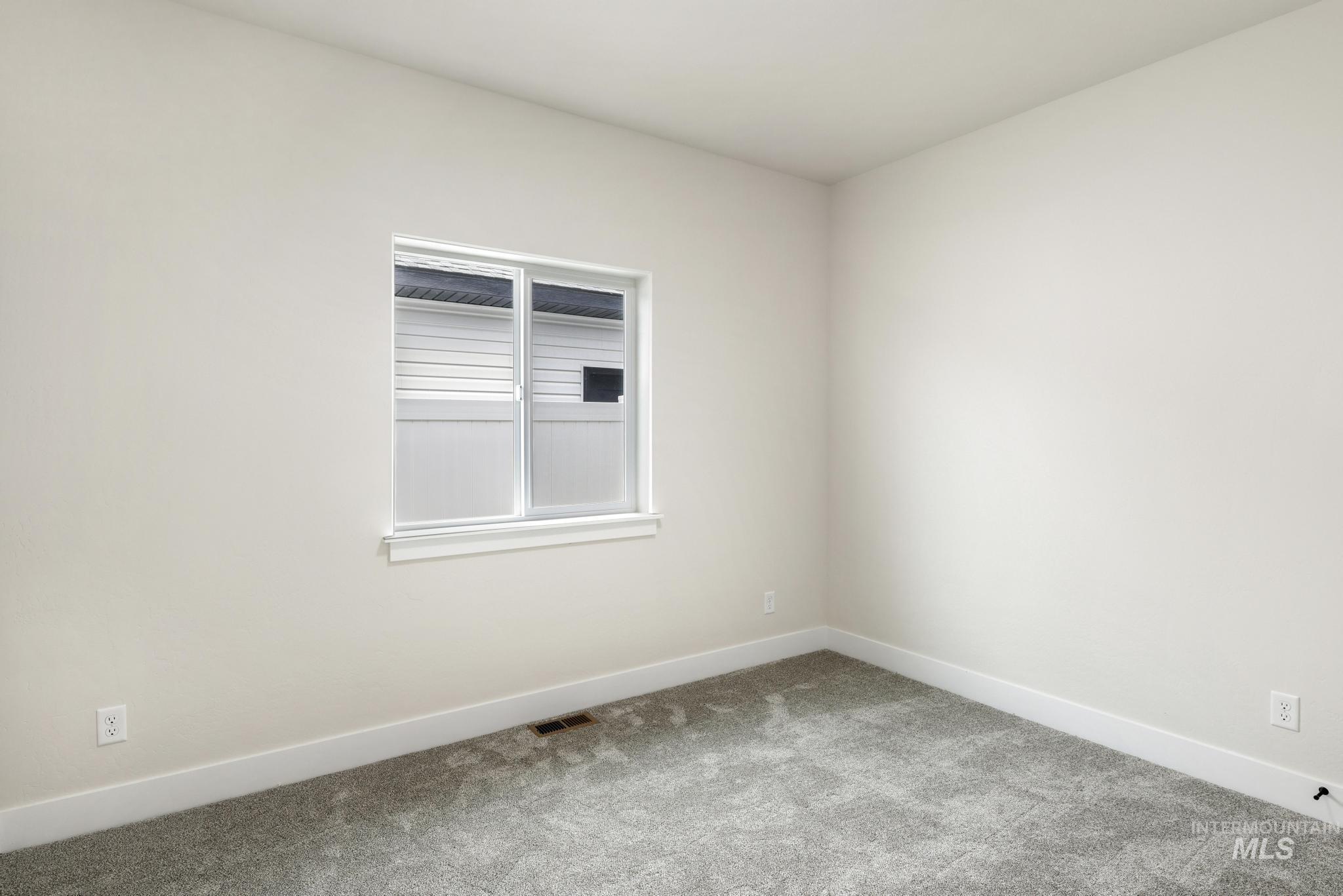 Carpeted empty room featuring baseboards