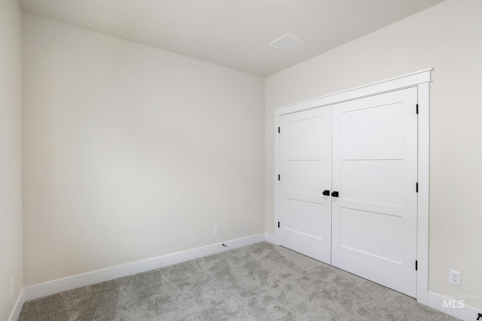 Unfurnished bedroom with carpet and a closet