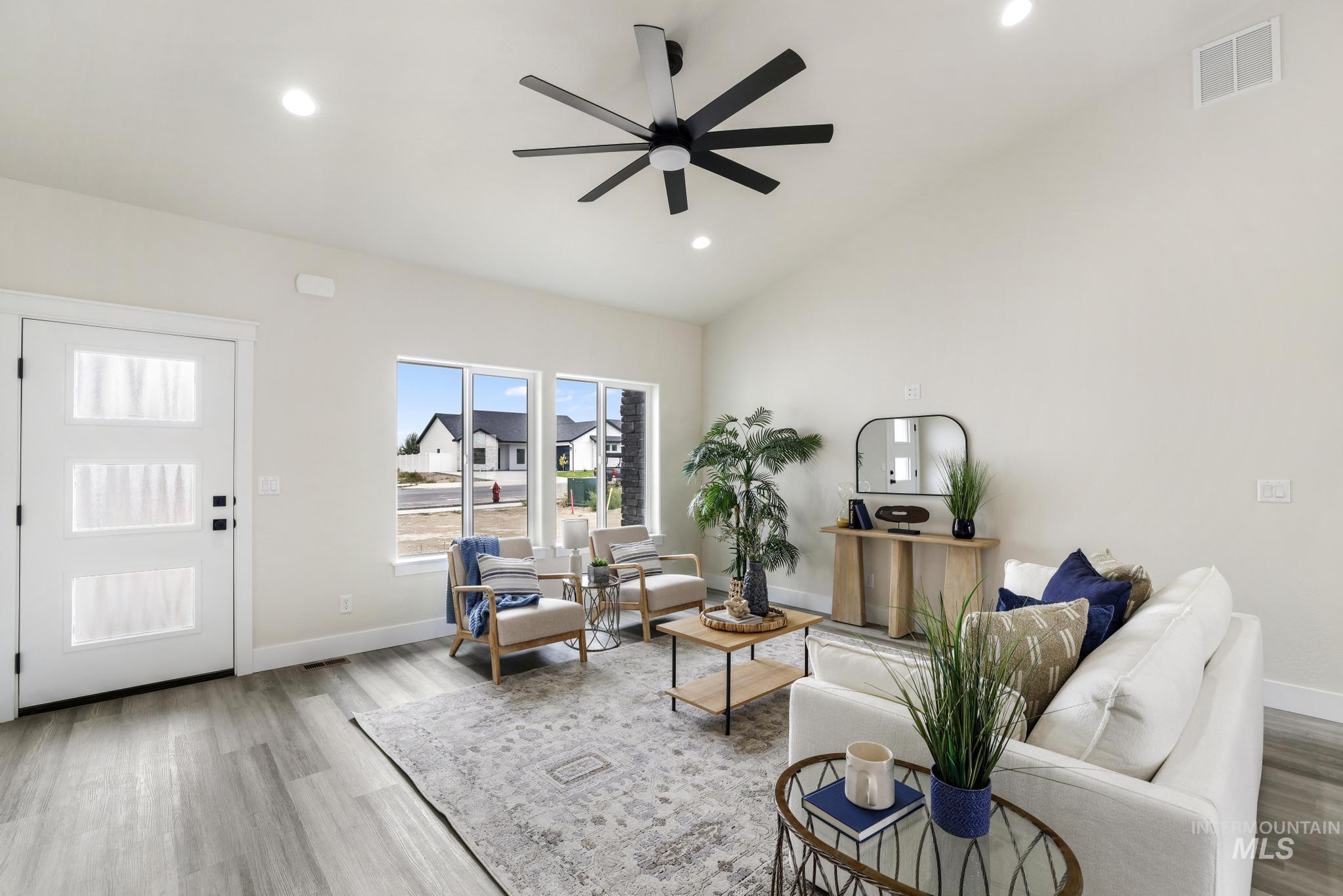 Living area featuring light wood-style flooring, lofted ceiling, recessed lighting, and ceiling fan