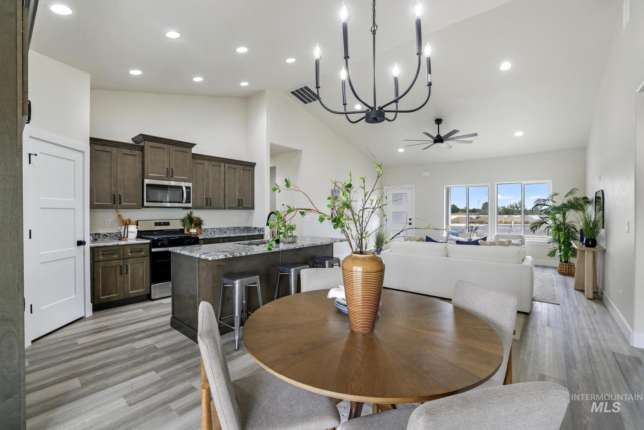 Dining room with recessed lighting, a chandelier, light wood-style floors, high vaulted ceiling, and a ceiling fan