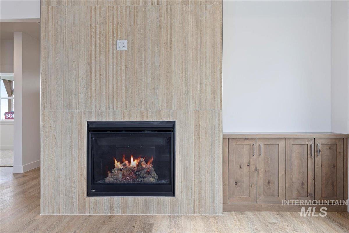 Detailed view of wood finished floors and a glass covered fireplace