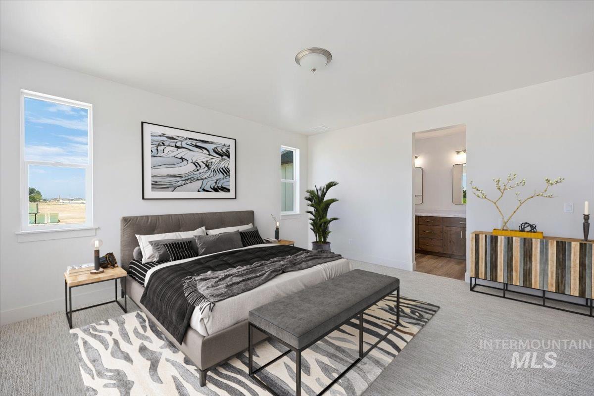 Carpeted bedroom featuring baseboards and connected bathroom