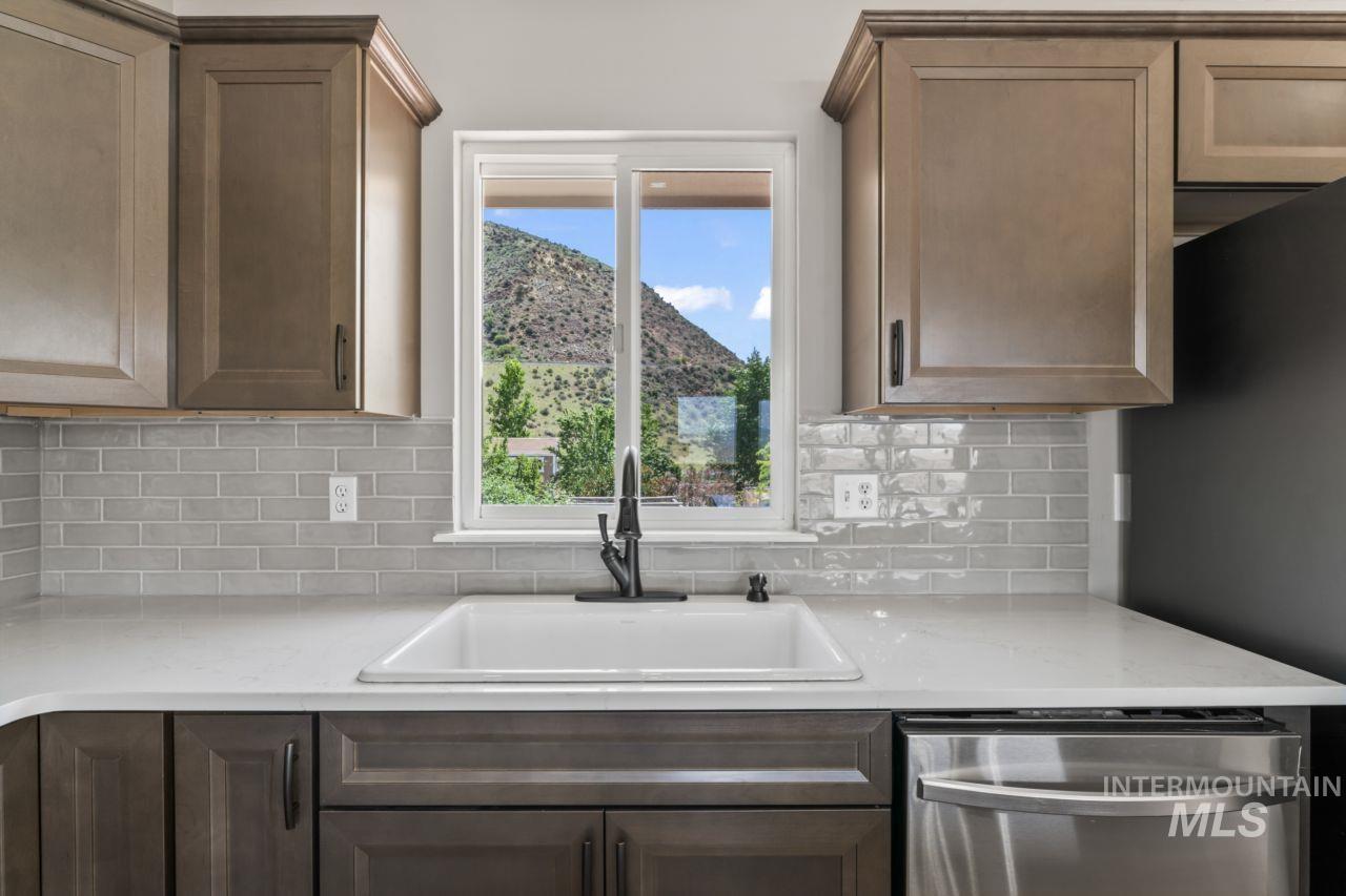 Kitchen with dishwasher, decorative backsplash, and refrigerator