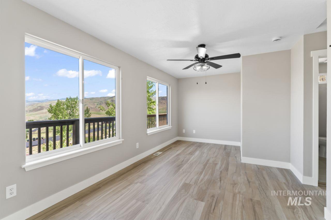 Spare room with wood finished floors and ceiling fan