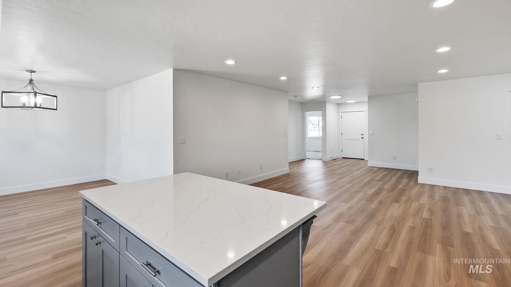 Kitchen with gray cabinets, open floor plan, a kitchen island, recessed lighting, and light wood-type flooring