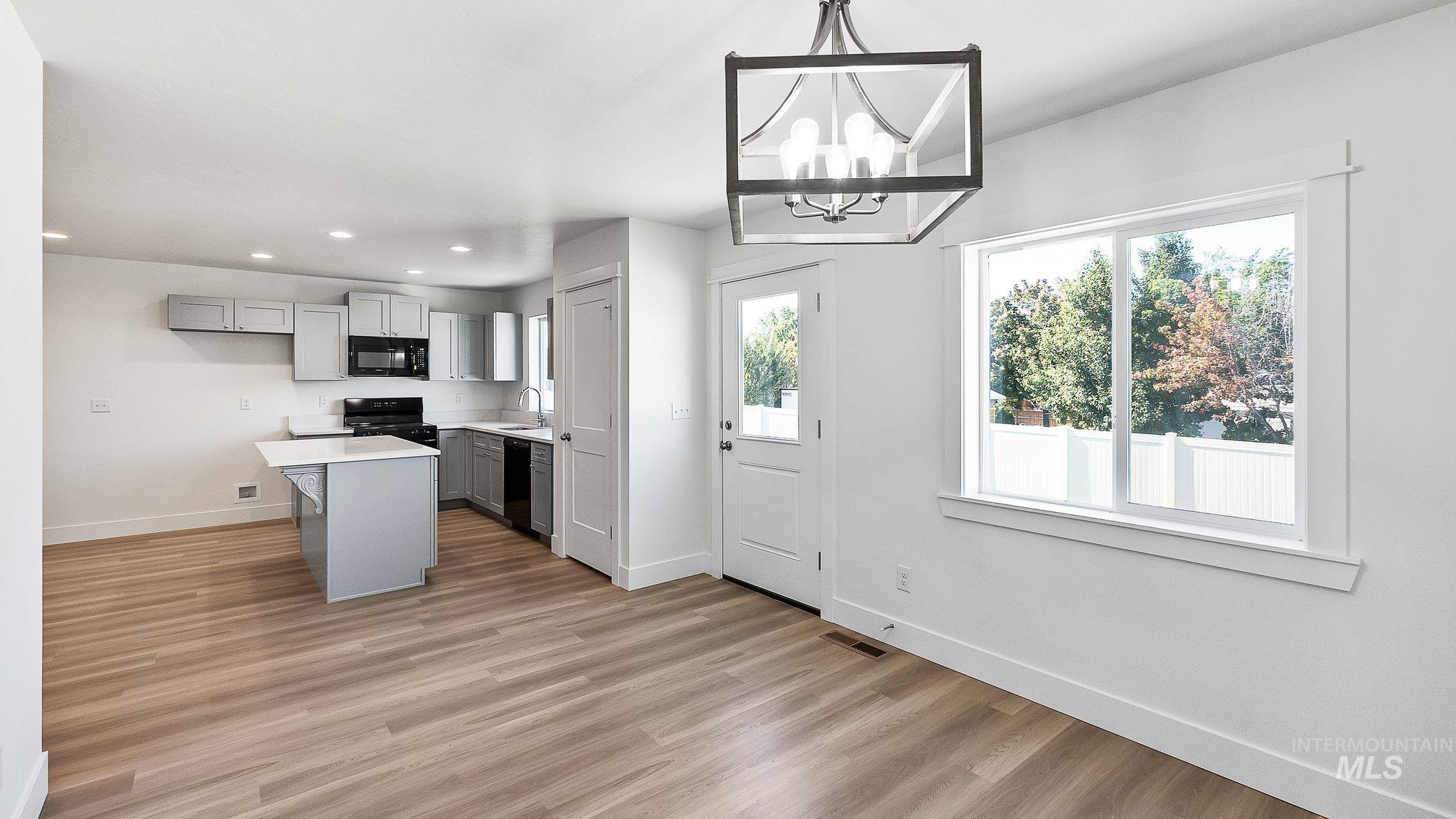 Kitchen featuring gray cabinets, light countertops, light wood-style floors, recessed lighting, and a center island