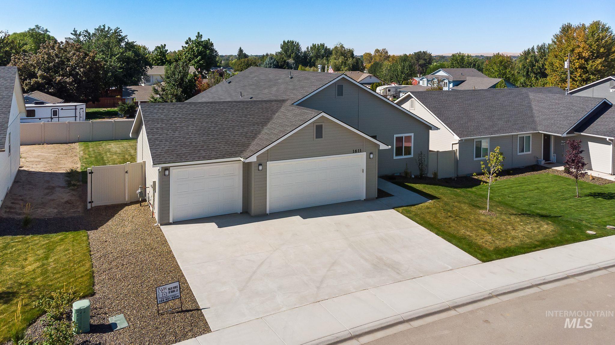 Ranch-style home with roof with shingles, an attached garage, driveway, a gate, and a residential view