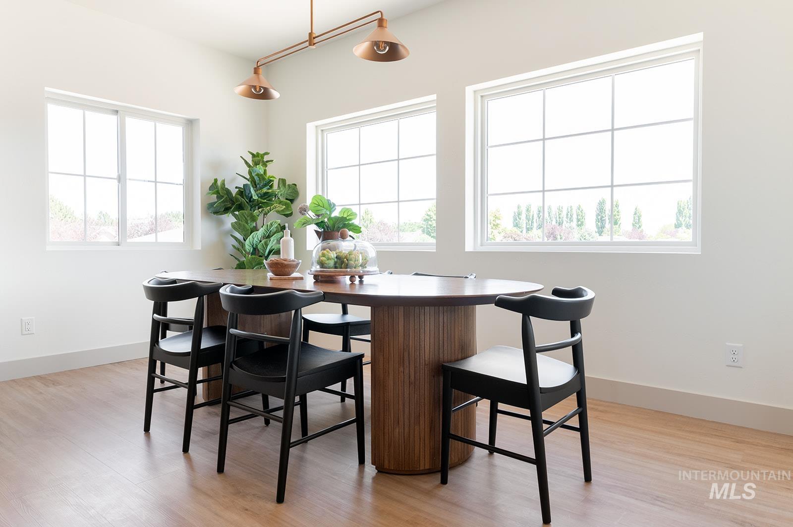 Dining space with light wood-type flooring and baseboards