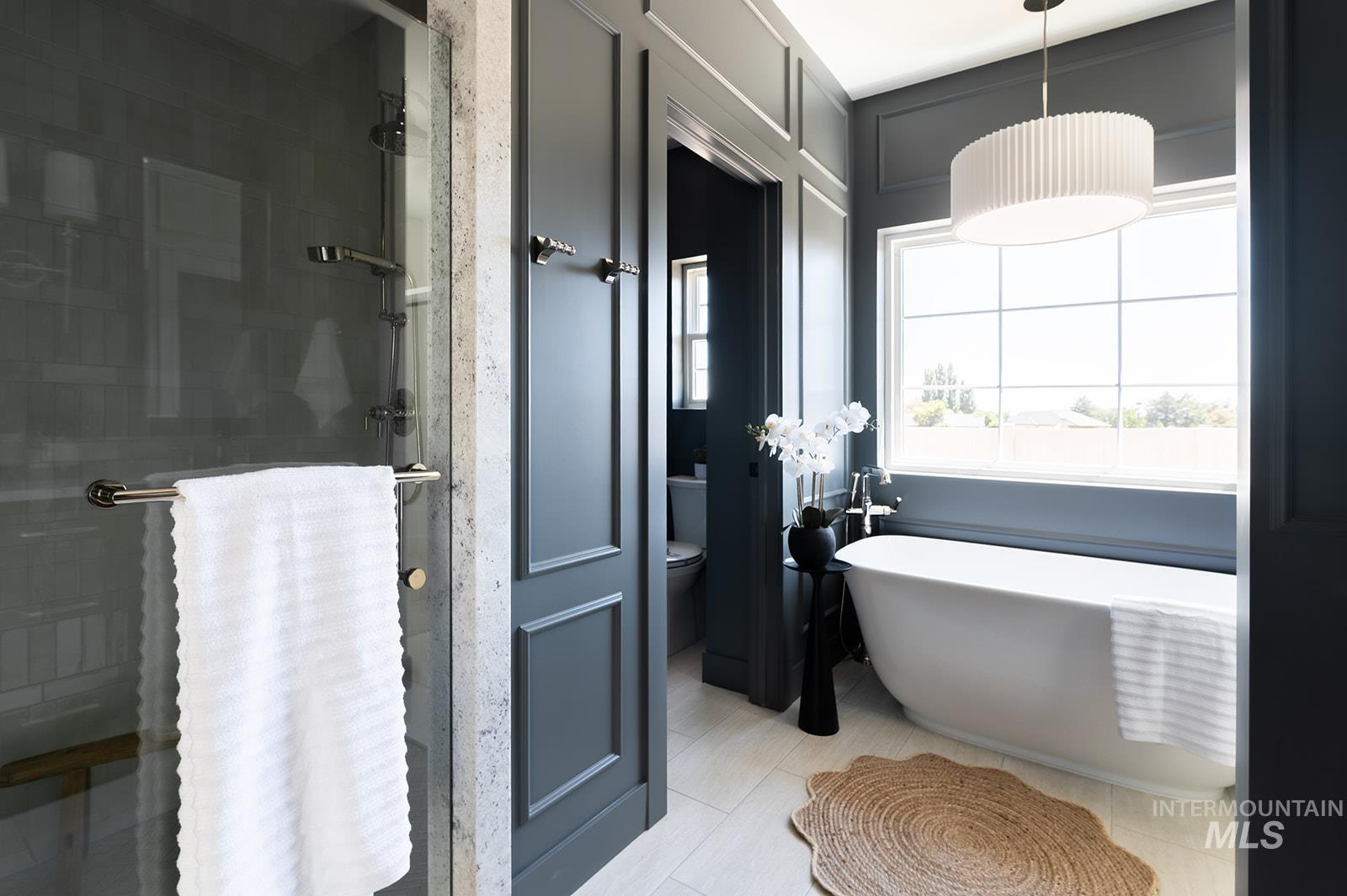 Bathroom featuring tile patterned floors, a freestanding bath, and a stall shower