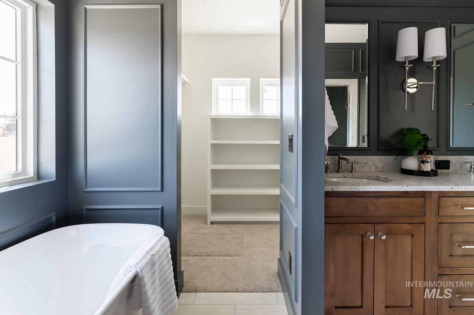 Bathroom featuring a soaking tub, double vanity, and tile patterned floors