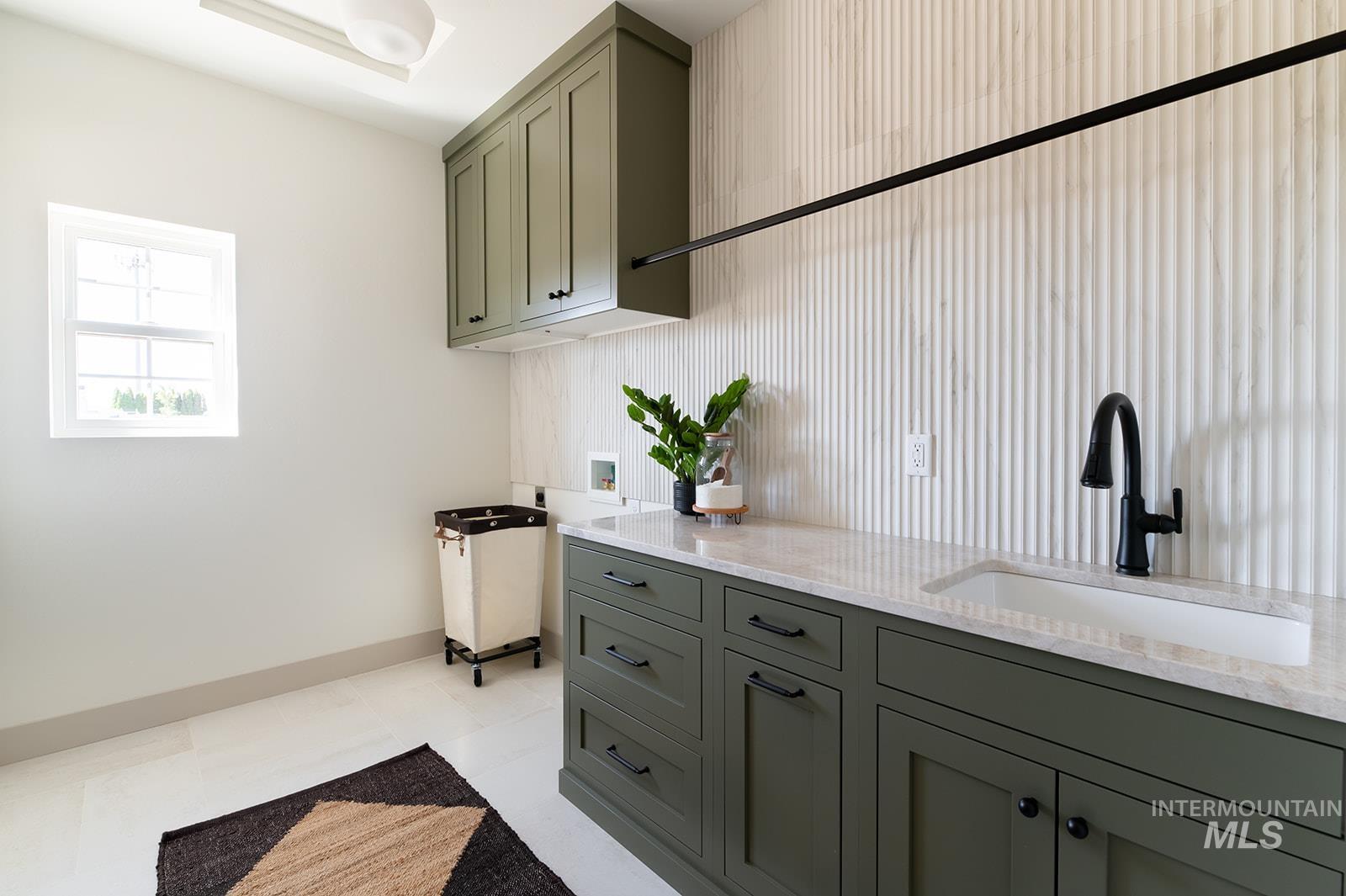 Laundry room featuring hookup for a washing machine, cabinet space, and light tile patterned flooring