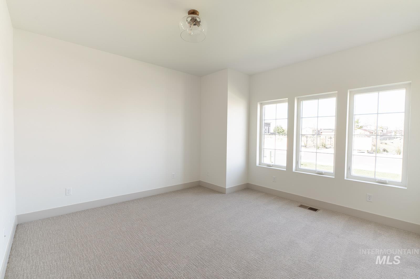 Empty room featuring light colored carpet