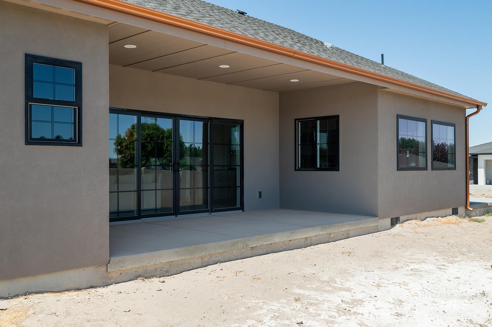 Rear view of house featuring a patio, stucco siding, crawl space, and roof with shingles