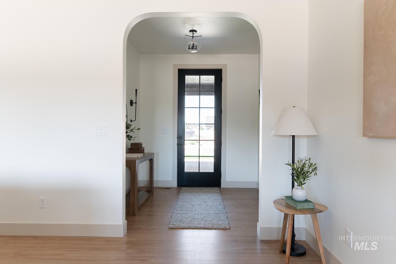 Foyer entrance with wood finished floors and arched walkways