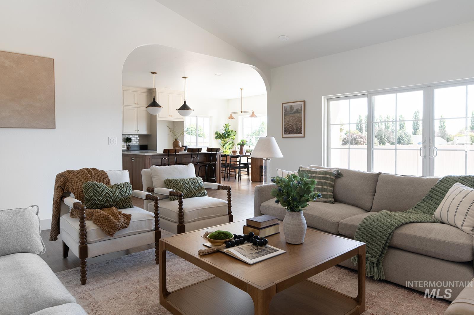Living area with arched walkways and vaulted ceiling