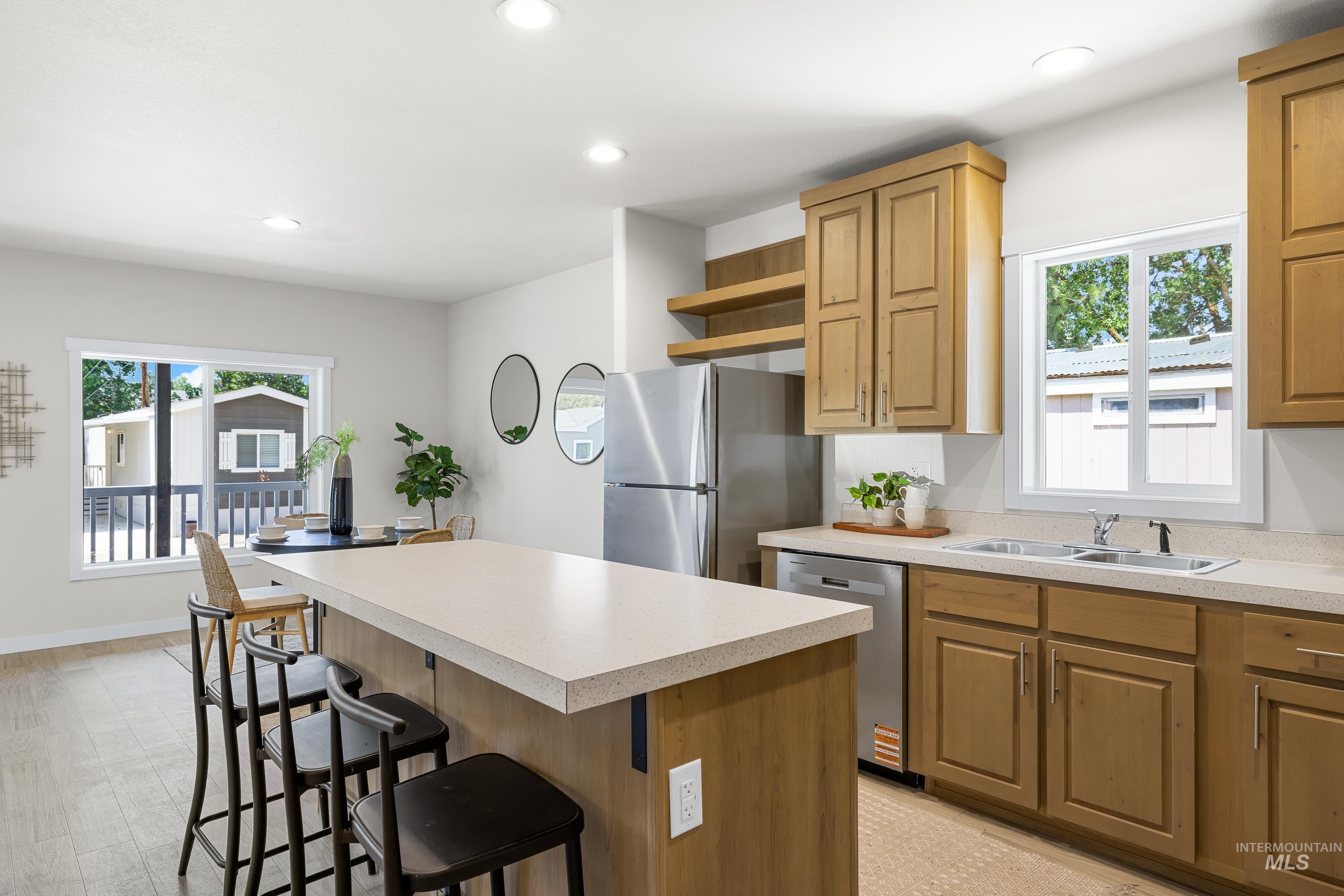 Kitchen featuring appliances with stainless steel finishes, open shelves, a kitchen breakfast bar, healthy amount of natural light, and recessed lighting