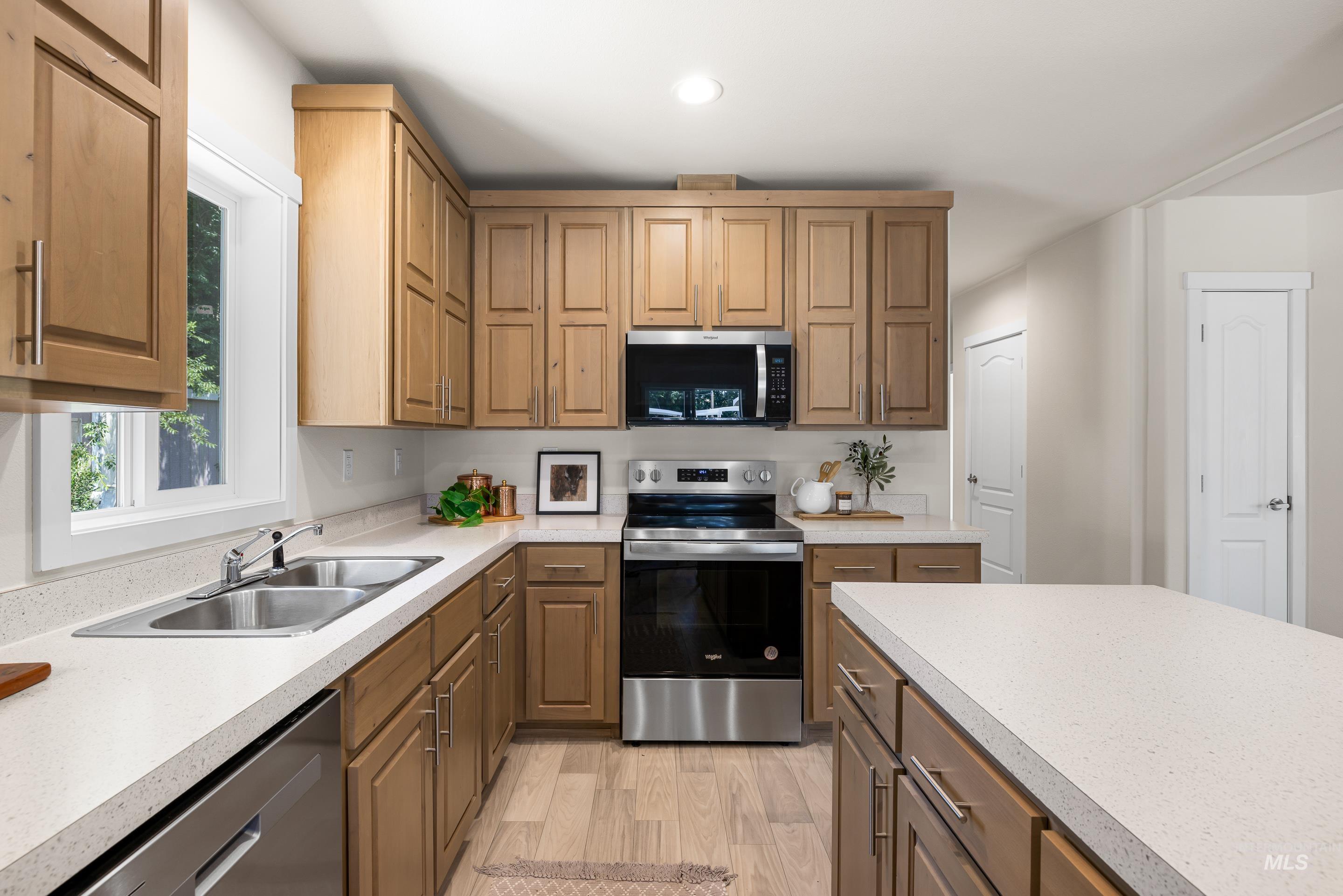 Kitchen featuring stainless steel appliances, light wood-style flooring, light countertops, and recessed lighting