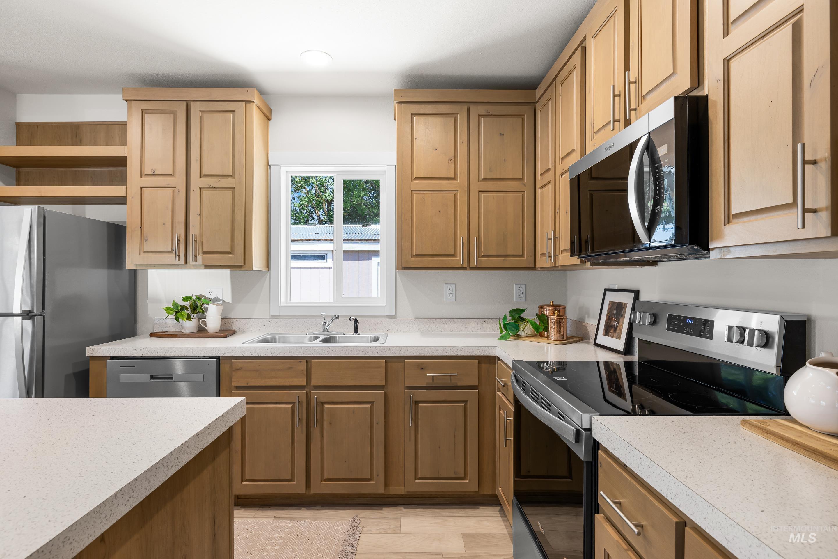 Kitchen featuring stainless steel appliances, light countertops, light wood-type flooring, open shelves, and recessed lighting