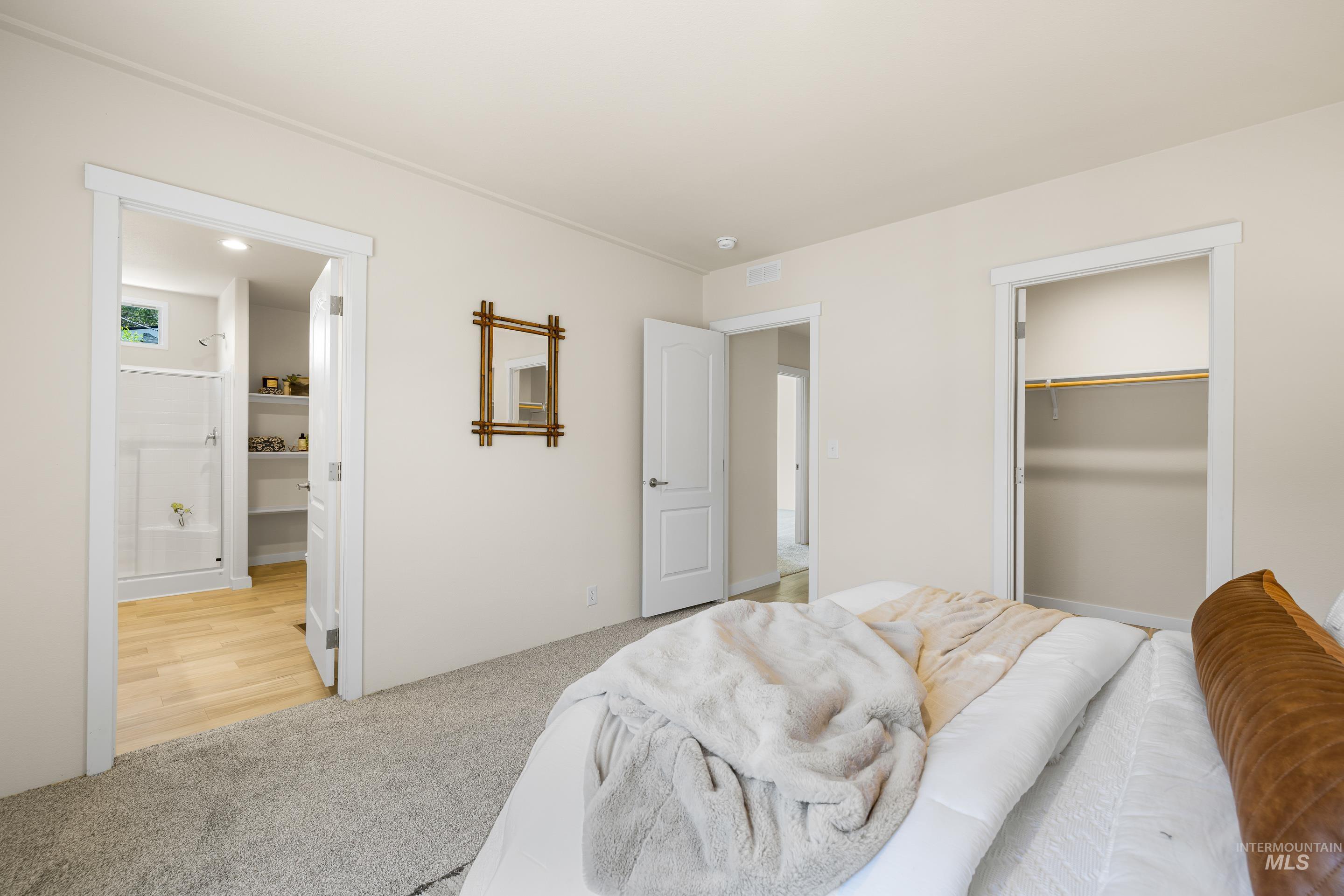 Bedroom featuring light carpet, connected bathroom, a spacious closet, and a closet