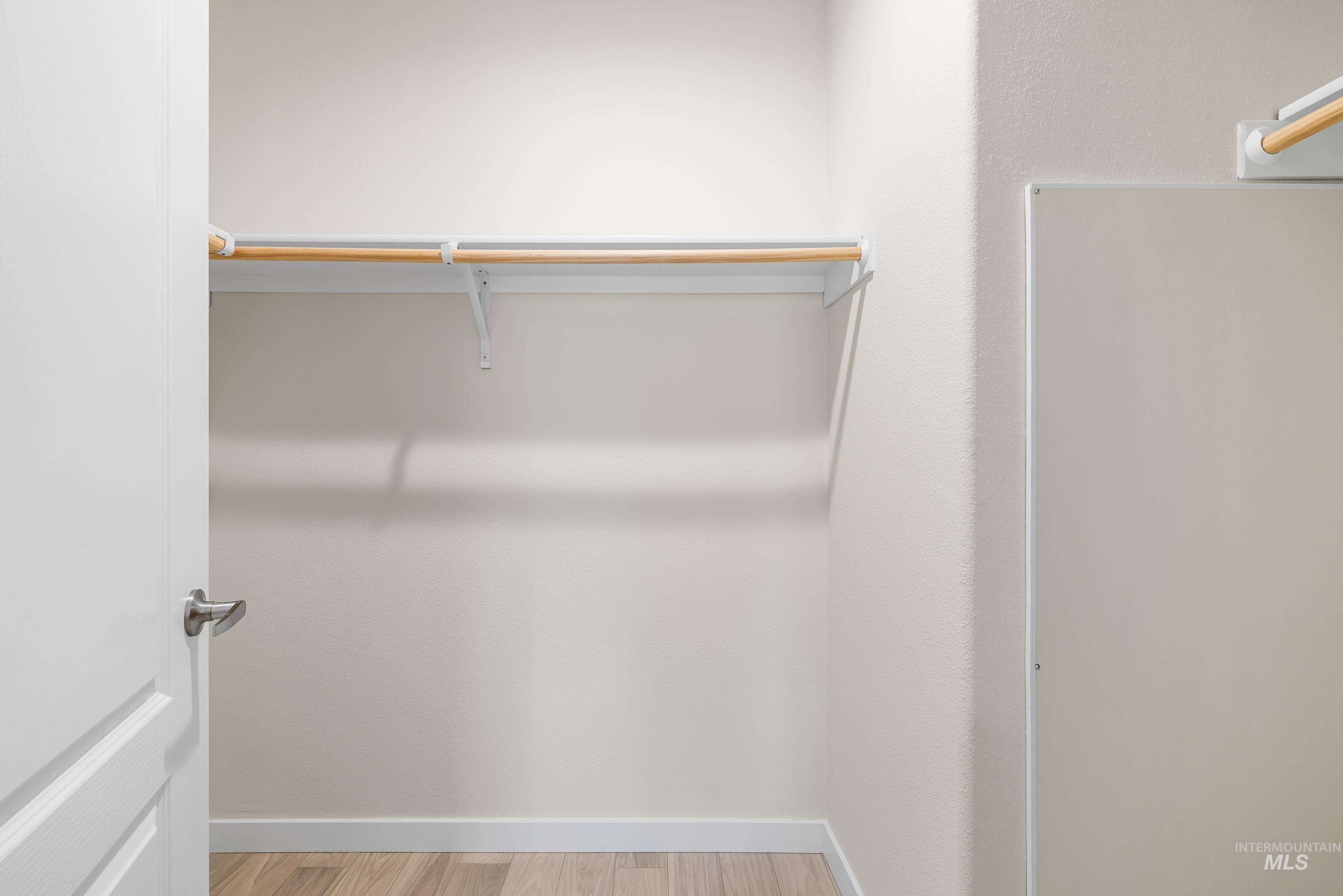 Walk in closet with light wood-style floors