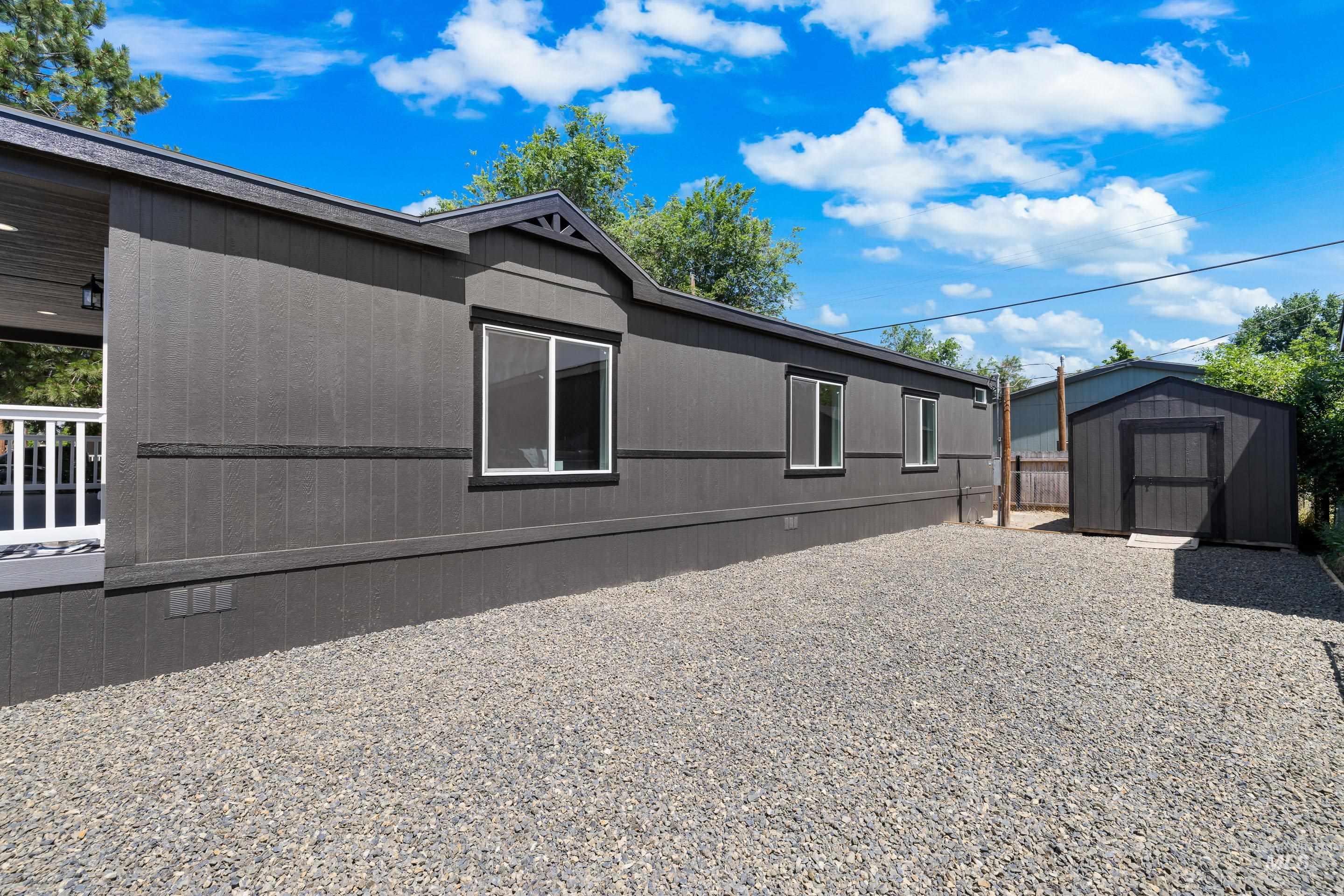View of side of home featuring a storage shed